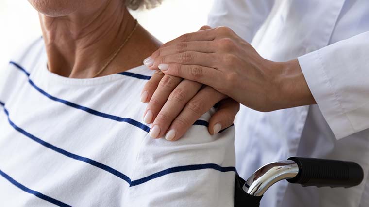Händer på axeln hos en senior person, genrebild