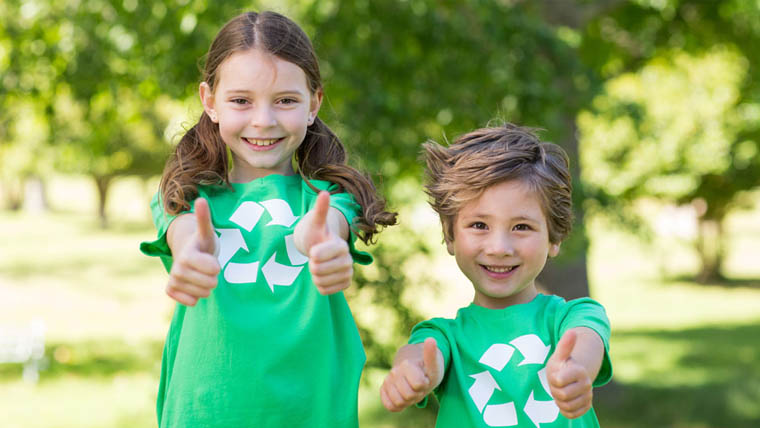 Två barn gör tummen upp för återvinning, foto
