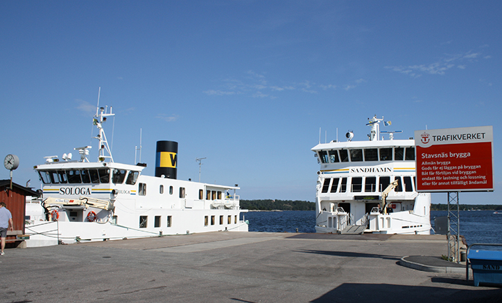Två skärgårdsbåtar ligger vid bryggan i Stavsnås vinterhamn.