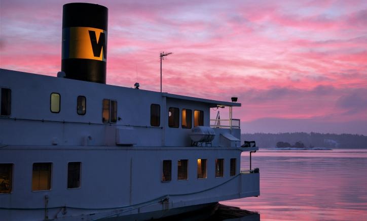 Vaxholmsbolagsbåt i solnedgång. Godsservice.