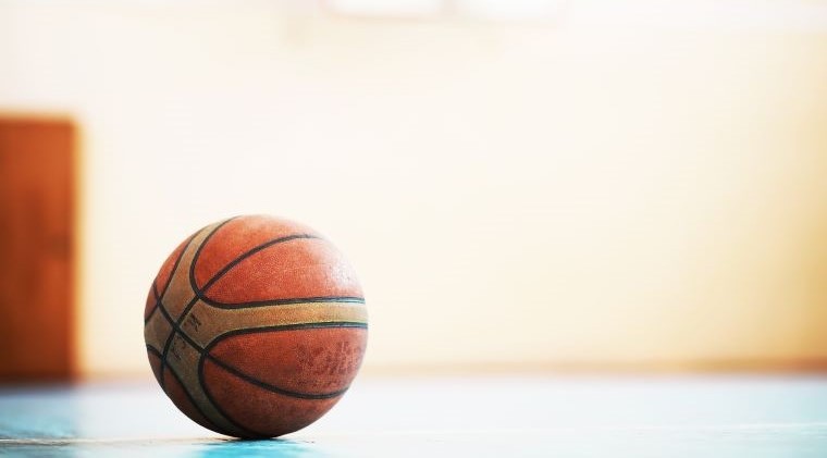 En basketball som ligger på golvet i en idrottshall